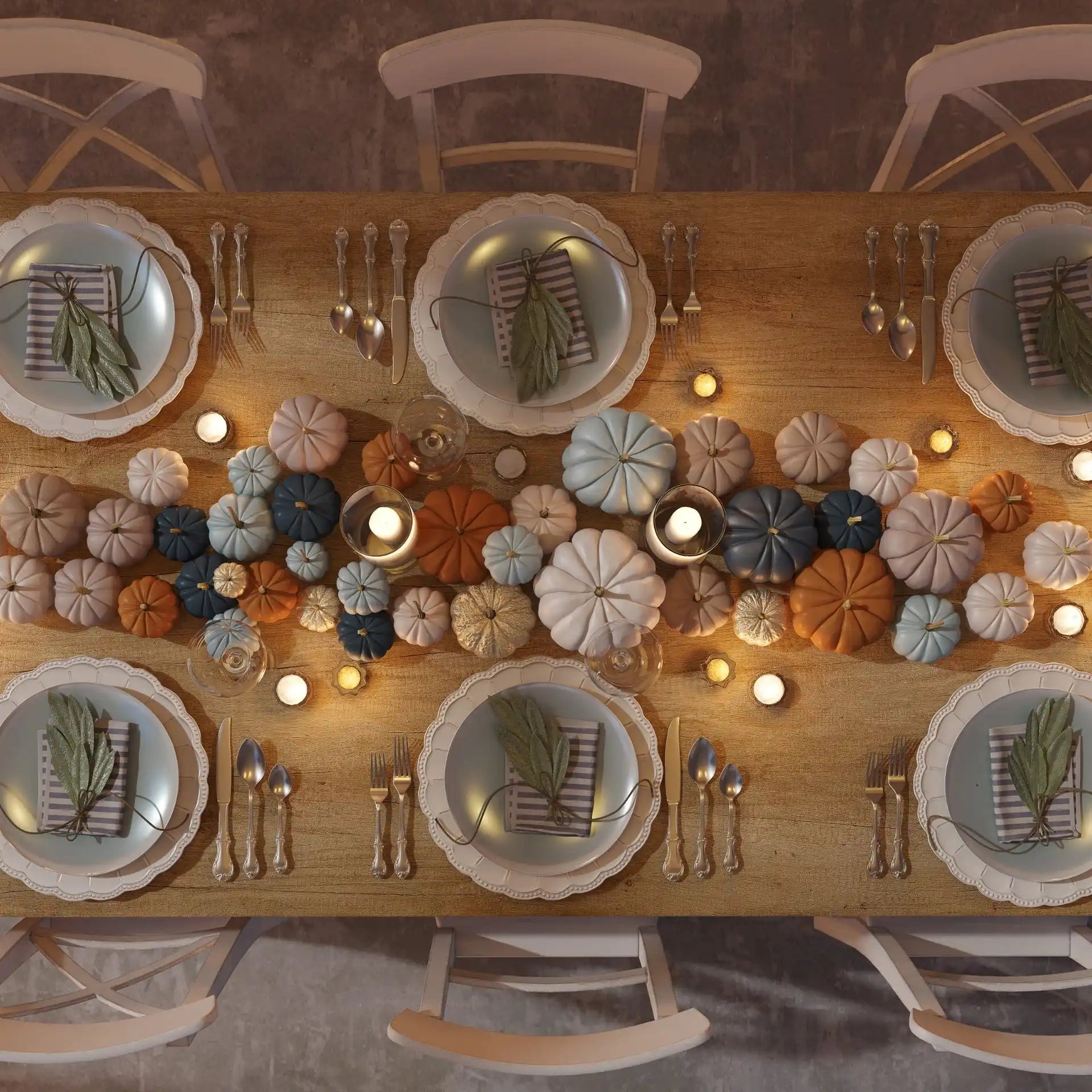 A festive autumn dining table set with decorative pumpkins and place settings.