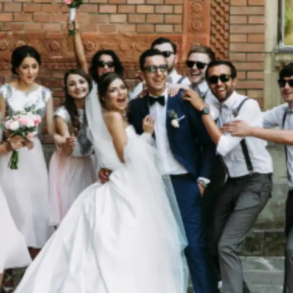 A smiling wedding party with the bride and groom at the center.