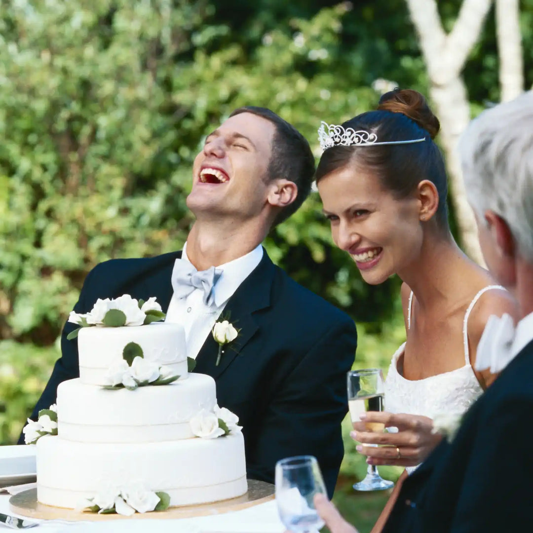 Three-tiered white wedding cake decorated with white flowers.