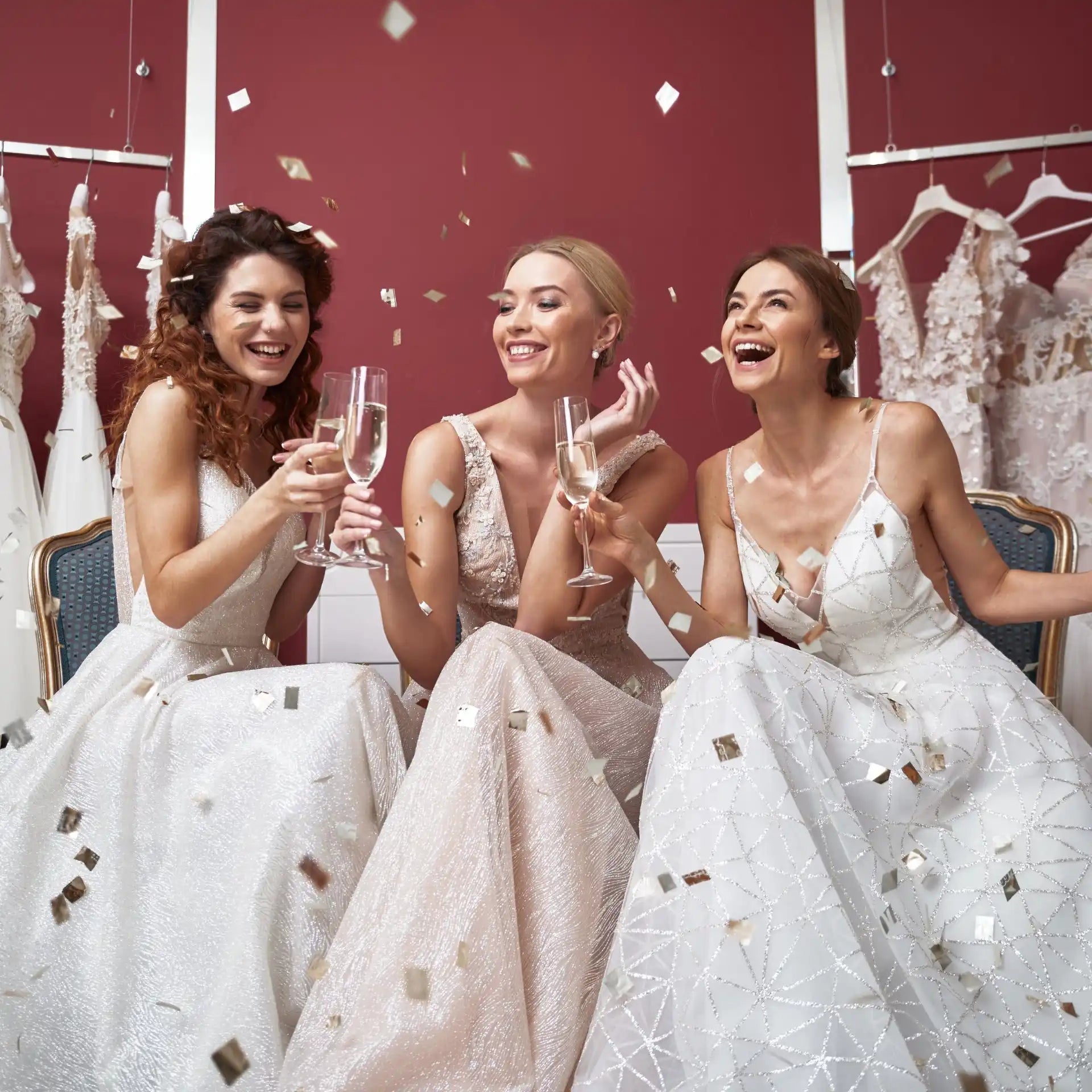 Three women celebrating in wedding dresses.
